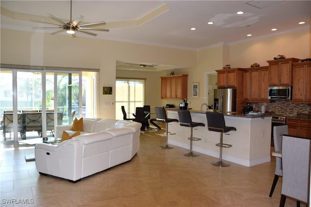 living room featuring ceiling fan and crown molding