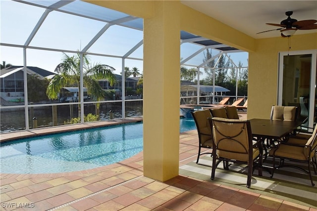 view of swimming pool with glass enclosure, ceiling fan, and a patio