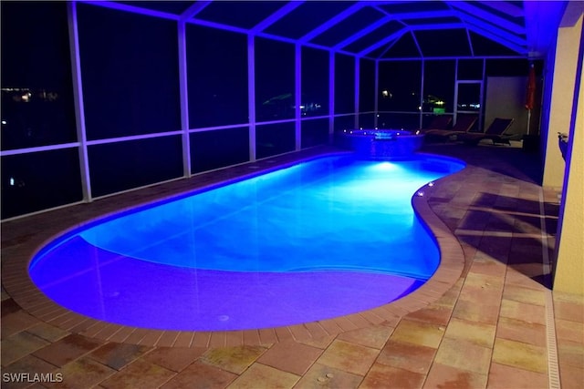 view of pool with an in ground hot tub, glass enclosure, and a patio area