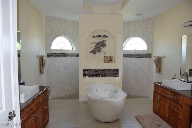 bathroom featuring tile patterned flooring, vanity, plenty of natural light, and tile walls