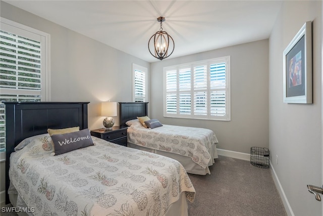 carpeted bedroom featuring a chandelier