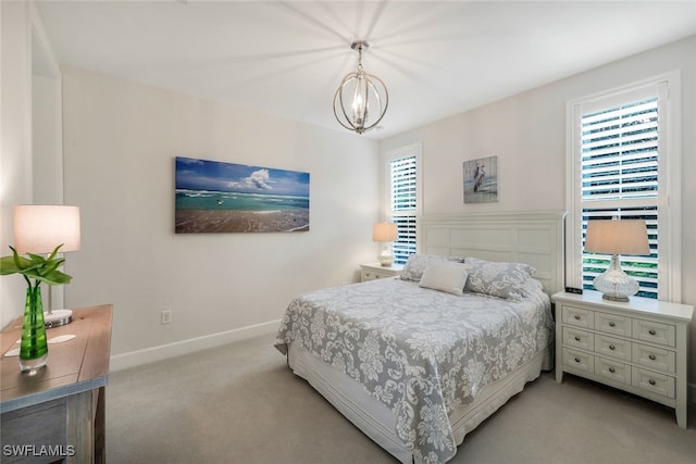 bedroom featuring multiple windows, light carpet, and a chandelier