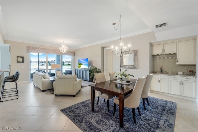 tiled dining room with crown molding and an inviting chandelier