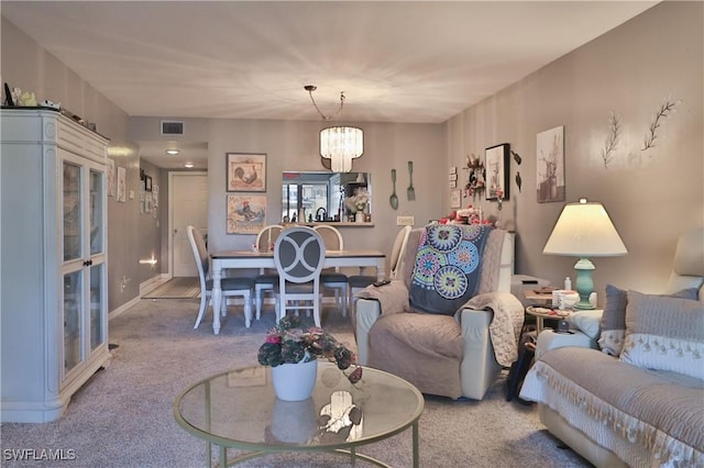 living room with carpet and an inviting chandelier