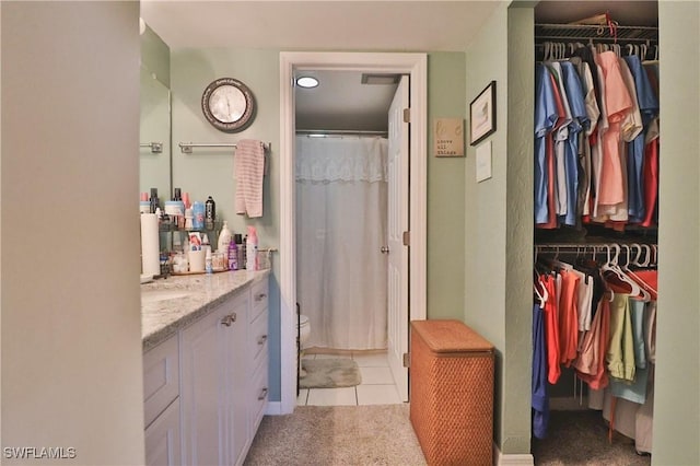 bathroom featuring tile patterned floors, vanity, and curtained shower