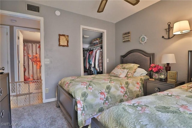 carpeted bedroom with ceiling fan, a spacious closet, and a closet