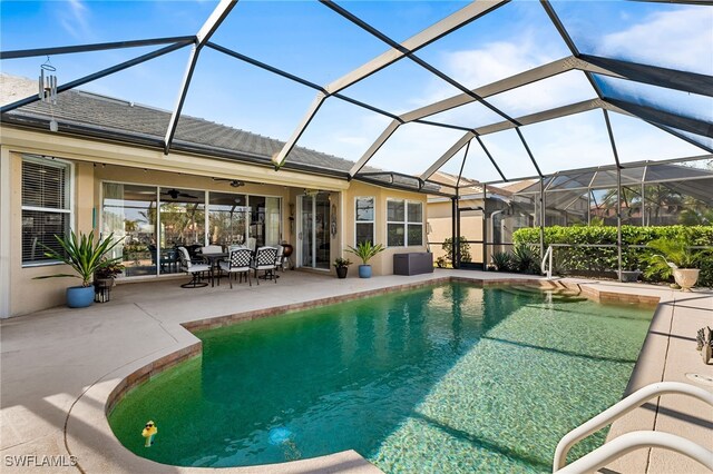 pool with a lanai, a patio area, and ceiling fan