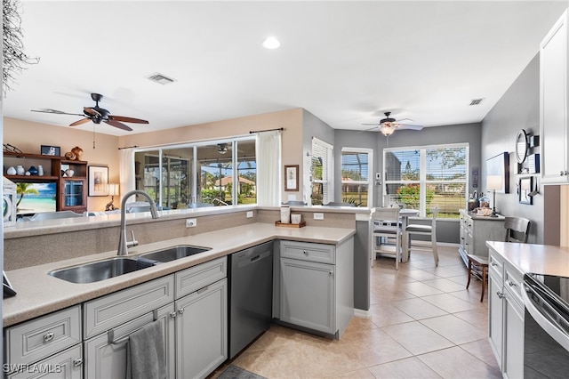 kitchen with a sink, visible vents, light countertops, and stainless steel dishwasher