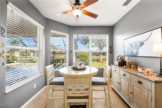 dining space featuring a ceiling fan, visible vents, baseboards, and light tile patterned flooring