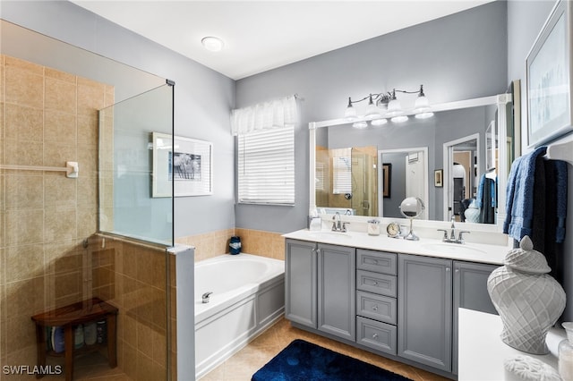 full bathroom featuring double vanity, a garden tub, tile patterned flooring, a shower stall, and a sink