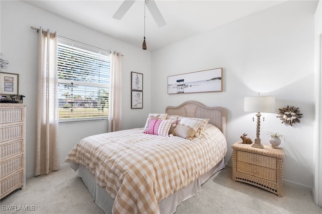 bedroom with ceiling fan, baseboards, and light colored carpet