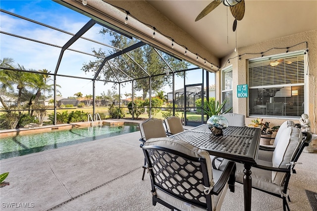 view of patio with ceiling fan and glass enclosure