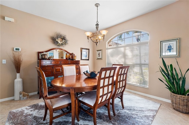 dining space featuring light tile patterned floors, plenty of natural light, a chandelier, and baseboards