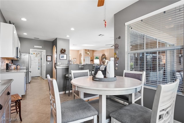 dining space with ceiling fan, baseboards, arched walkways, and recessed lighting