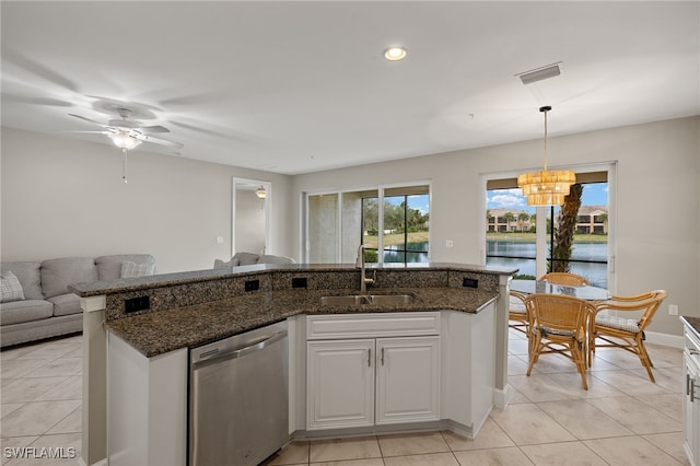 kitchen featuring a water view, dishwasher, sink, and white cabinetry