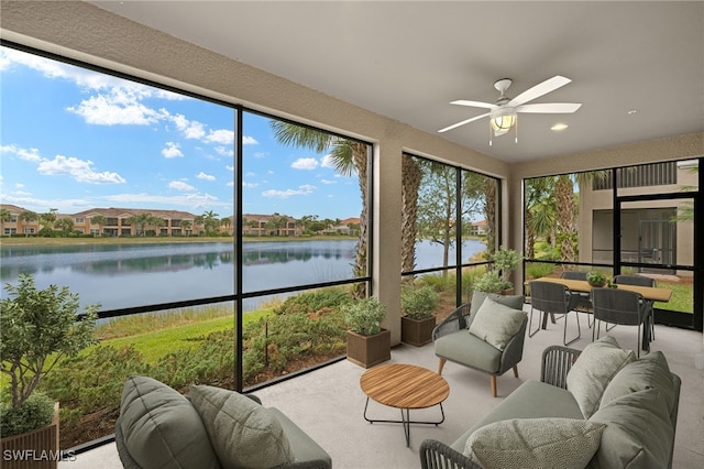 sunroom / solarium featuring a water view and ceiling fan