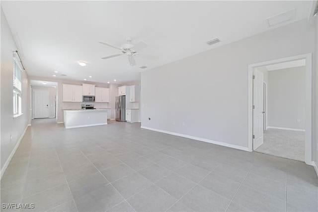 unfurnished living room with ceiling fan and light tile patterned flooring