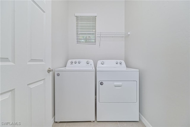 washroom with light tile patterned floors and washer and dryer