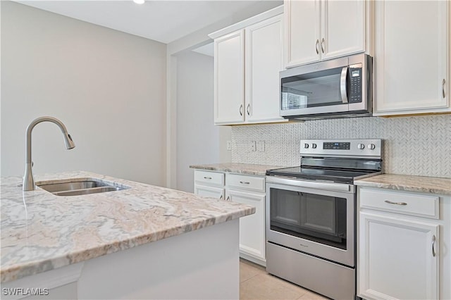 kitchen featuring sink, light stone counters, white cabinetry, and stainless steel appliances