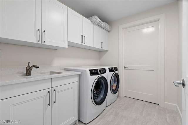 laundry room with sink, cabinets, and independent washer and dryer