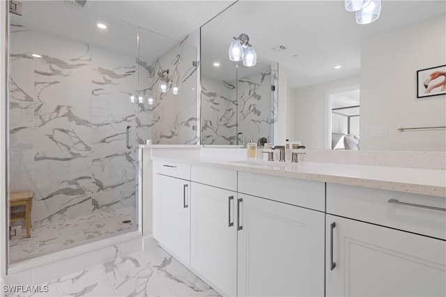 bathroom featuring a shower with door and vanity