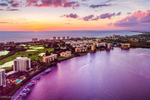 aerial view at dusk featuring a water view