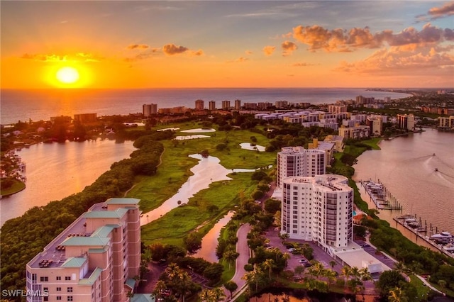 aerial view at dusk featuring a water view