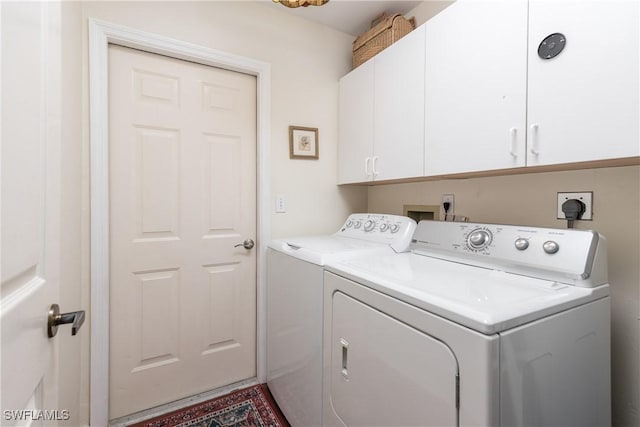 laundry room with washer and clothes dryer and cabinets