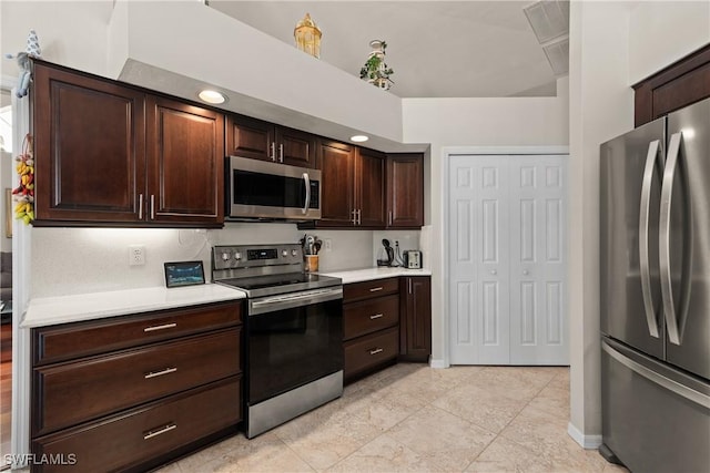 kitchen featuring stainless steel appliances, light tile patterned floors, and dark brown cabinetry