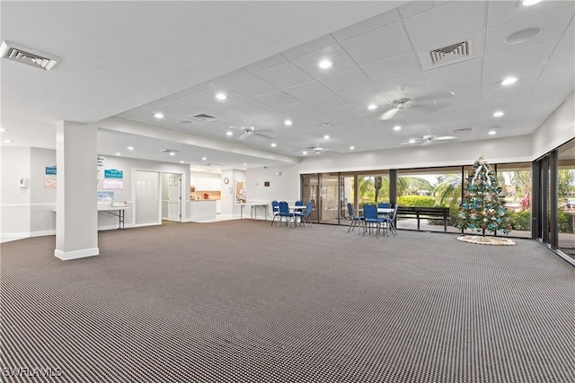 interior space with a paneled ceiling and carpet flooring