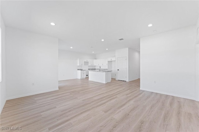 unfurnished living room with light hardwood / wood-style floors and sink