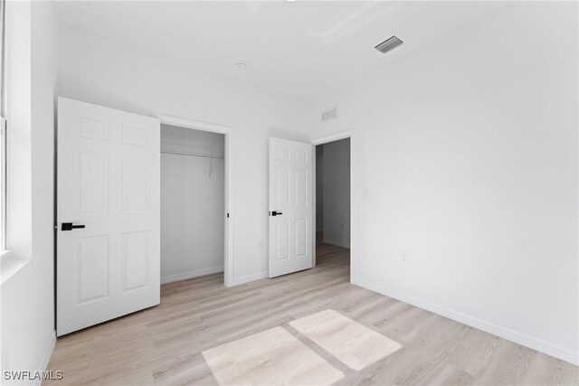 unfurnished bedroom featuring light hardwood / wood-style floors and a closet