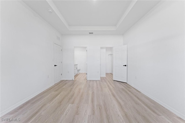 interior space featuring a raised ceiling and light hardwood / wood-style flooring