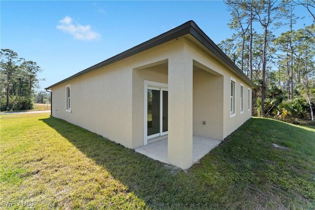 view of side of property with a patio area and a yard