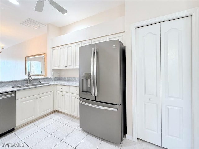 kitchen featuring appliances with stainless steel finishes, ceiling fan, sink, white cabinets, and light tile patterned flooring