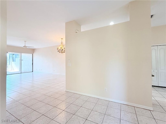 unfurnished room featuring ceiling fan with notable chandelier and light tile patterned flooring