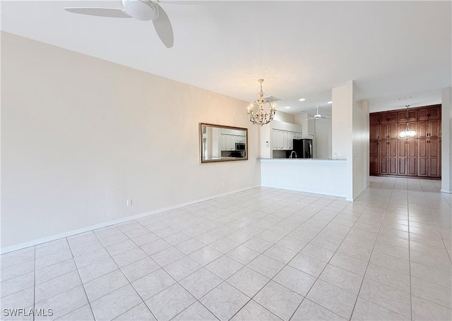 spare room with light tile patterned flooring and ceiling fan with notable chandelier