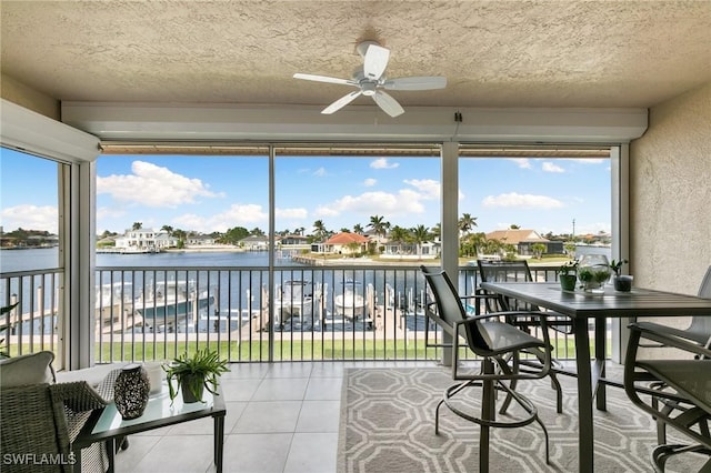 sunroom / solarium with a water view and ceiling fan