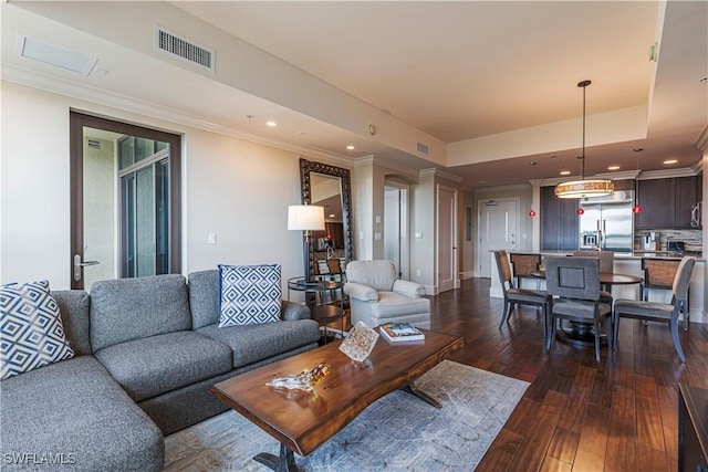 living area featuring dark wood-style floors, recessed lighting, a raised ceiling, visible vents, and ornamental molding