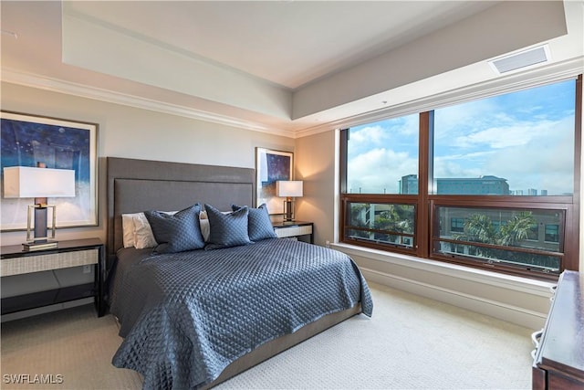 carpeted bedroom featuring ornamental molding and a raised ceiling