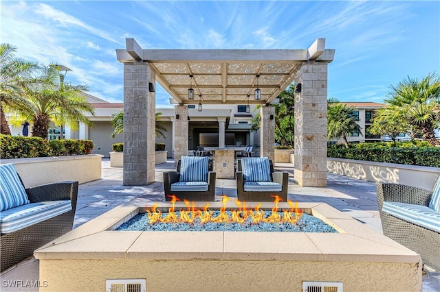 view of patio / terrace with an outdoor fire pit, a pergola, and exterior kitchen