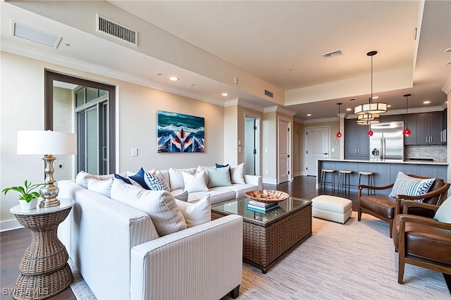 living room with recessed lighting, light wood-type flooring, crown molding, and baseboards