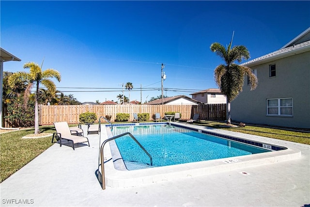 view of swimming pool with a yard