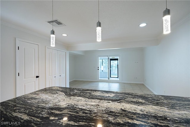 interior space featuring light tile patterned floors, two closets, and ornamental molding