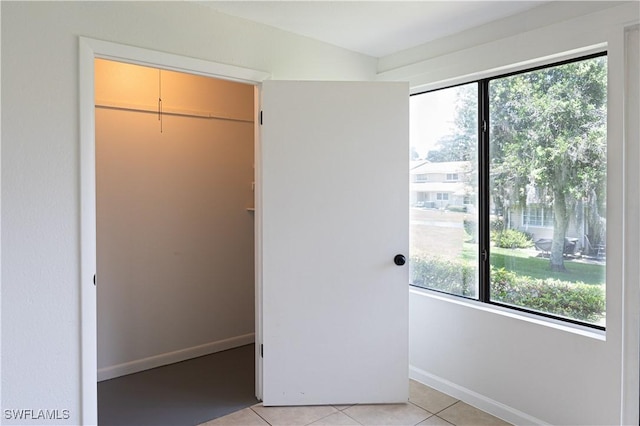 unfurnished bedroom featuring light tile patterned floors and a closet