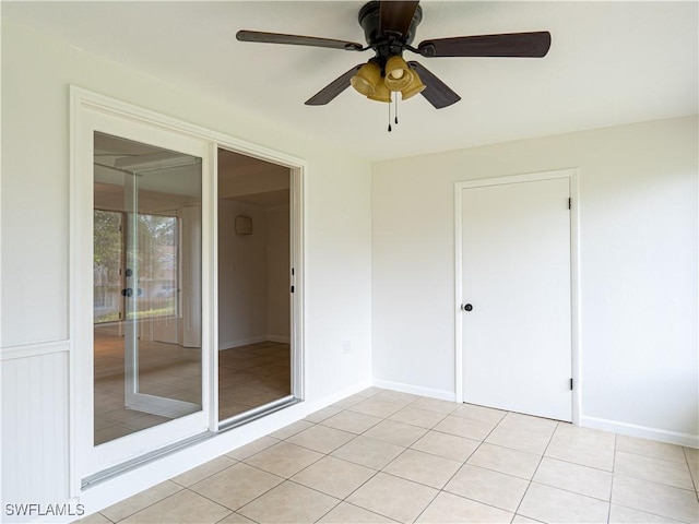 tiled spare room with ceiling fan