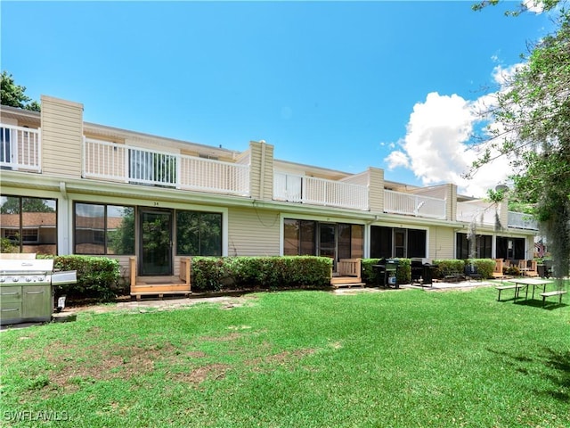 rear view of property with a lawn