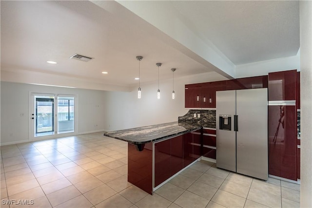 kitchen with kitchen peninsula, stainless steel refrigerator with ice dispenser, tasteful backsplash, light tile patterned floors, and hanging light fixtures