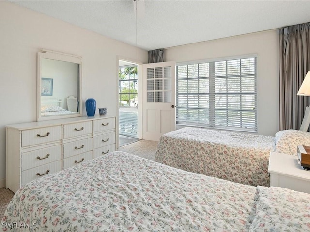 carpeted bedroom with access to exterior and a textured ceiling