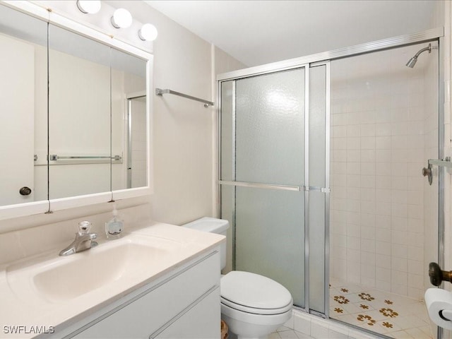 bathroom with vanity, a shower with shower door, and toilet